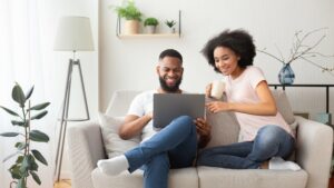 african american couple on couch with laptop